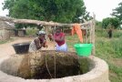 Zwei Frauen ziehen Wasser aus einem Brunnen