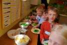 Kinder neben Schüsseln mit geschnittenem Gemüse und Dip.