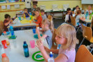 Kinder sitzen an Tischen und essen Wraps