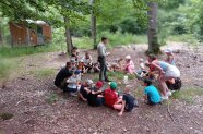 Kinder sitzen im Kreis im Wald