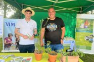 Berater am Infostand mit Blumentöpfen