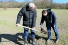 Lehrer auf Acker, Bodenprobe mit Spaten