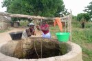 Zwei Frauen ziehen Wasser aus einem Brunnen