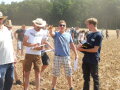 Studierende auf Stoppelfeld im sommer mit Strohüten