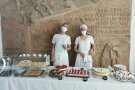 Frauen stehen hinter Kuchenbuffet