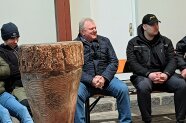 Landwirt sitzt mit Studierenden auf Bank