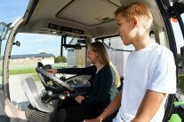 Zwei junge Landwirte am Lenkrad im Traktor