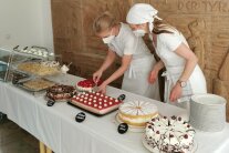 zwei Frauen mit Schürze am Kuchenbuffet