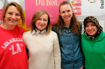 vier sehr verschiedene Frauen vor Plakaten