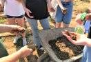 Schulklasse bei der Fingerprobe mit Erde in der Hand