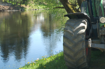 Traktor am Flussufer