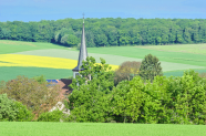 Landschaft mit Feldern, Wald und Kirchturm